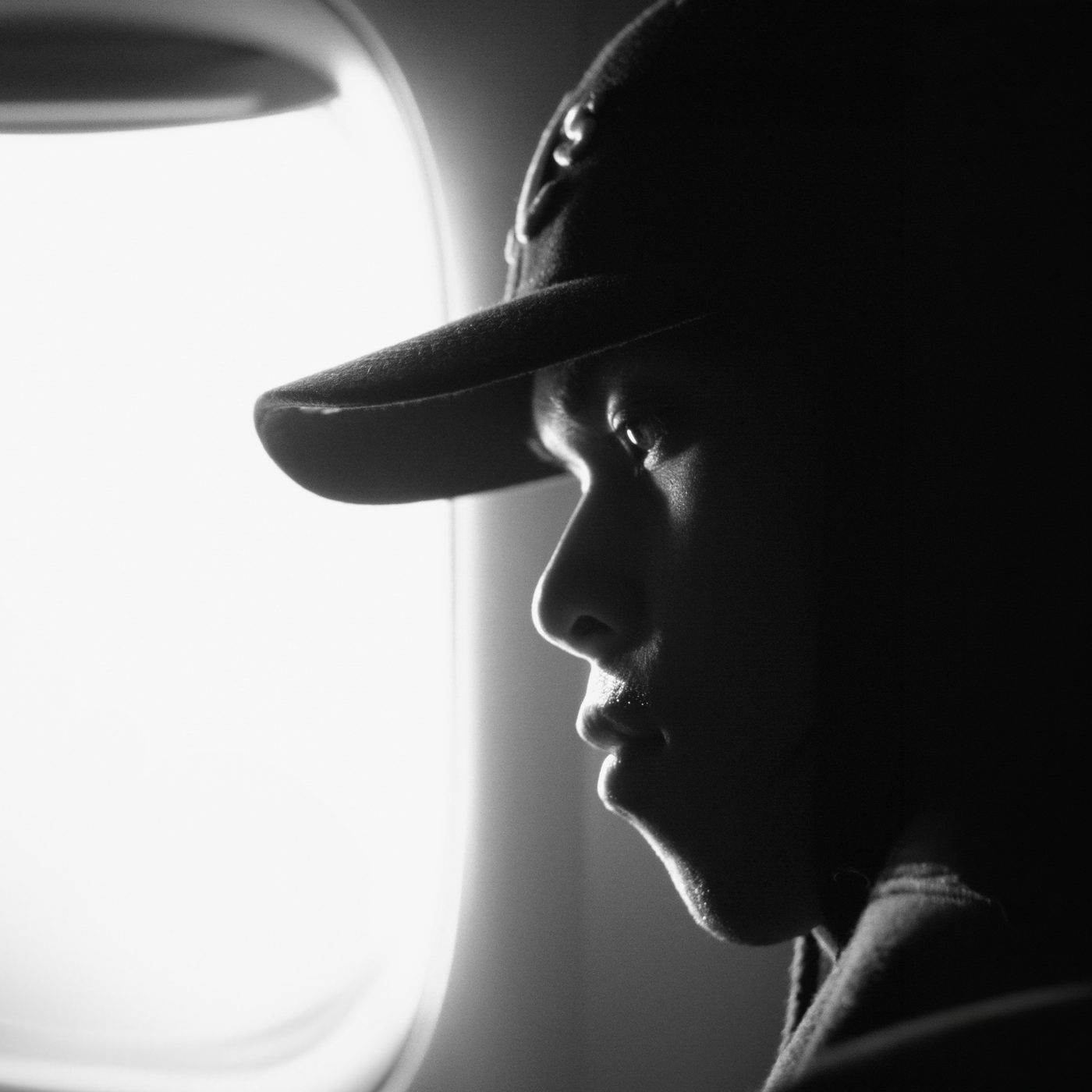 Black and white portrait of James Wajura by an aeroplane window