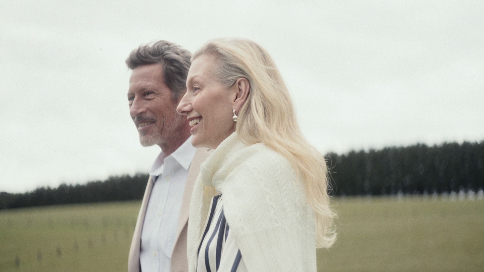 A man and woman laughing together in a paddock