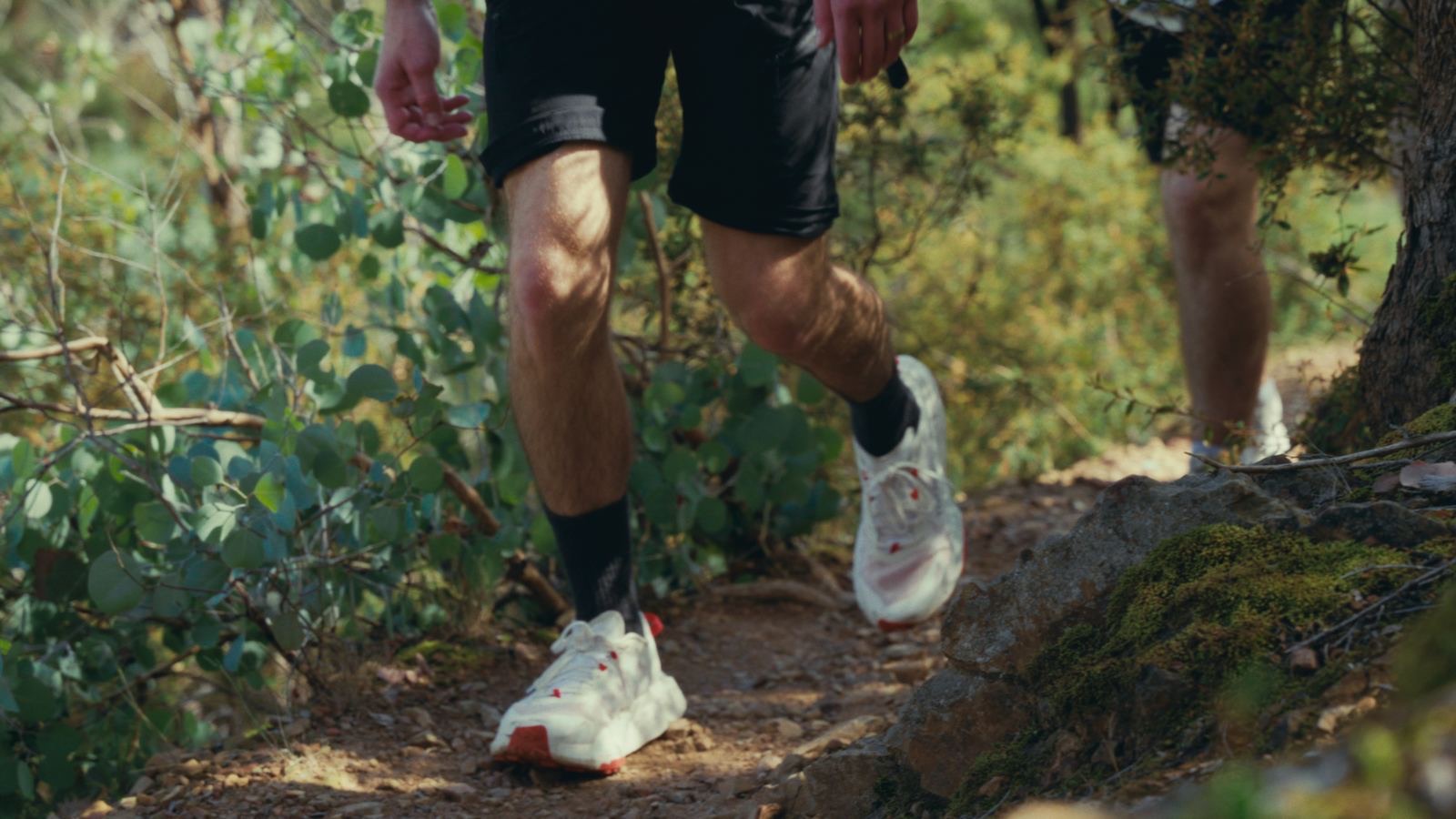 Trail runners stepping over a rocky track