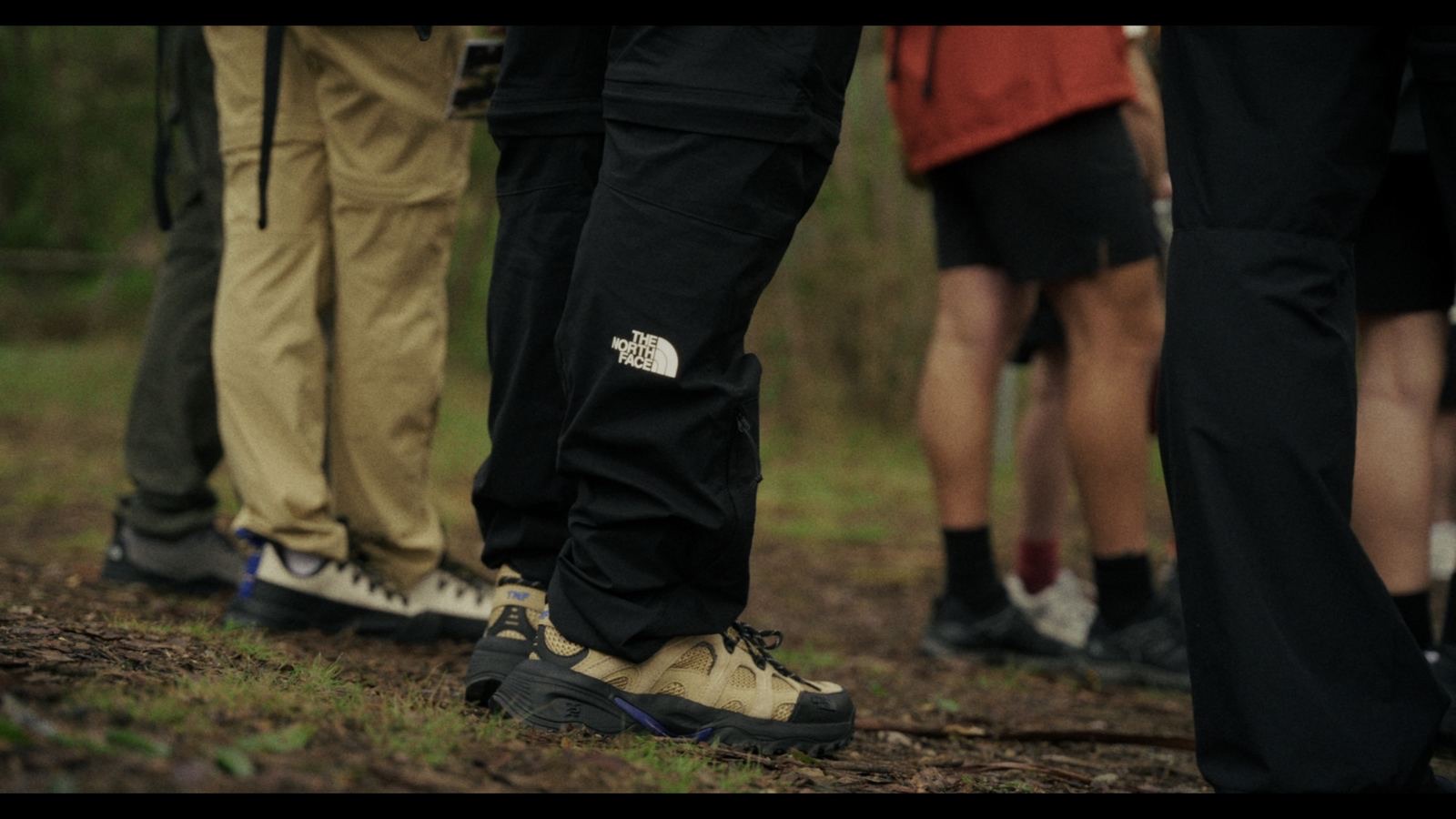 Hikers standing on the trail, boots and shell pants in frame